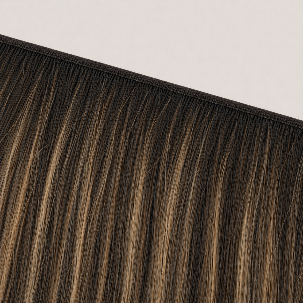 Flat butterfly weft seam of Stessia hair extensions in shade #1BT1B/4/Oak Balayage