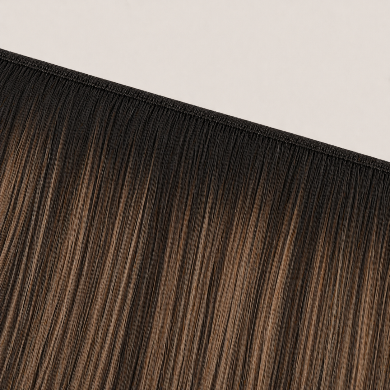 Flat butterfly weft seam of Stessia hair extensions in shade #1B/6 Balayage