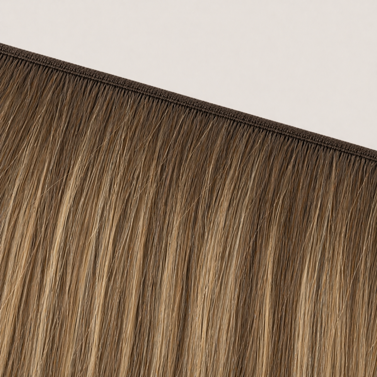 Flat butterfly weft seam of Stessia hair extensions in shade #6/6T24 Balayage